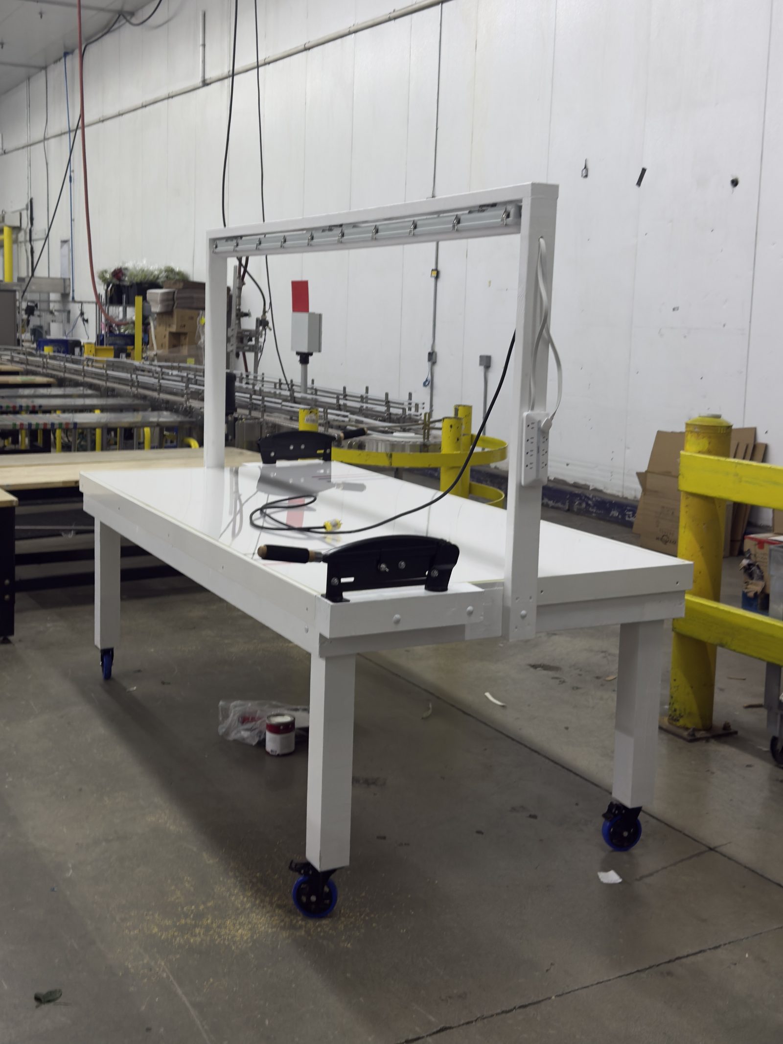 White powder-coated steel QC table on blue casters in production facility